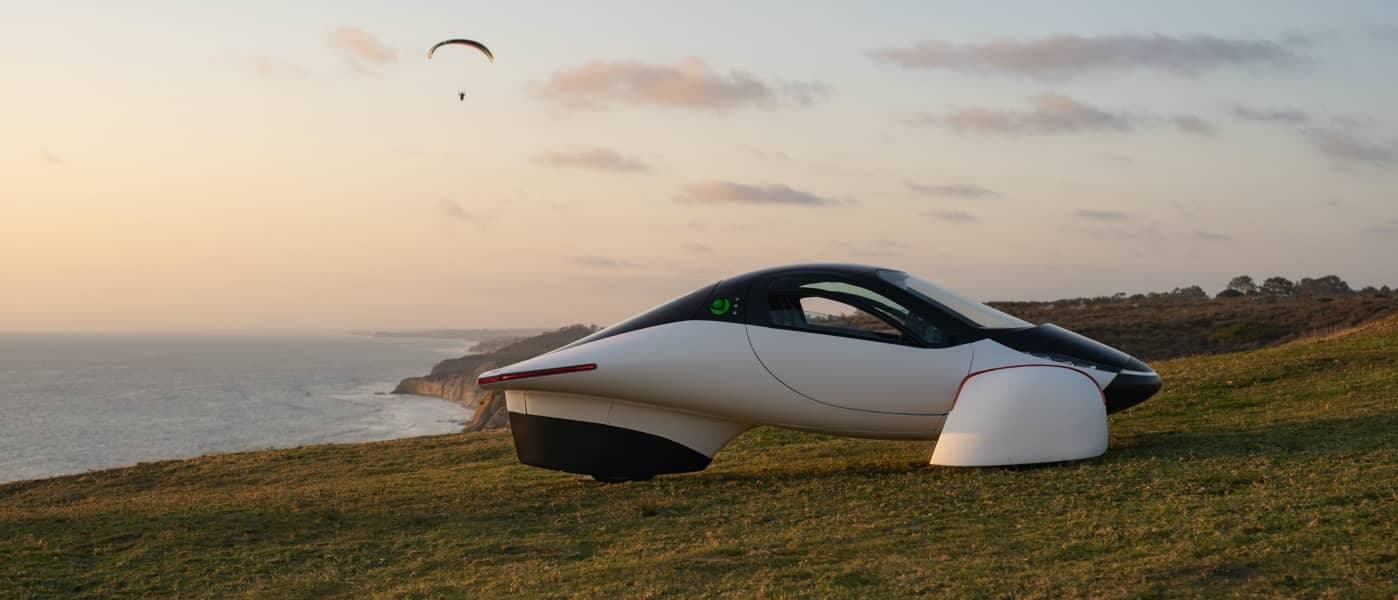 Aptera vehicle on coastal cliff at sunset