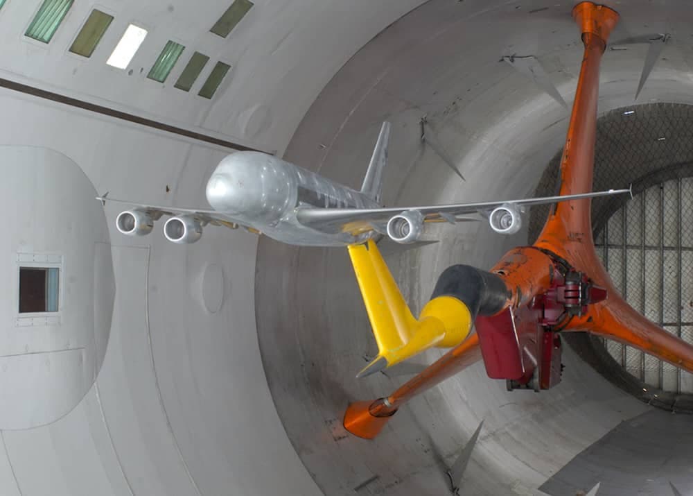 Silver scale model of an aeroplane mounted in the wind tunnel test section via a Z sting mount