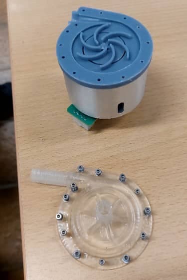 Prototype pump head with the components disassembled: housing with impeller on the drive unit, and the transparent cover