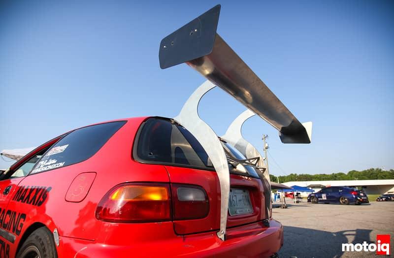 A large modified spoiler attached to the rear of a red honda civic