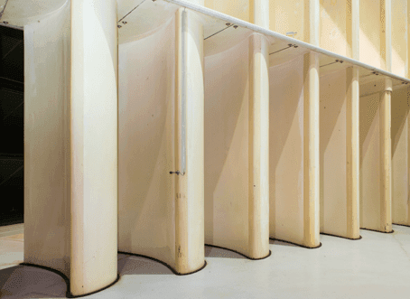 Close up photo of large aerofoil-shaped turning vanes at the corner of a the Icing Research Wind Tunnel