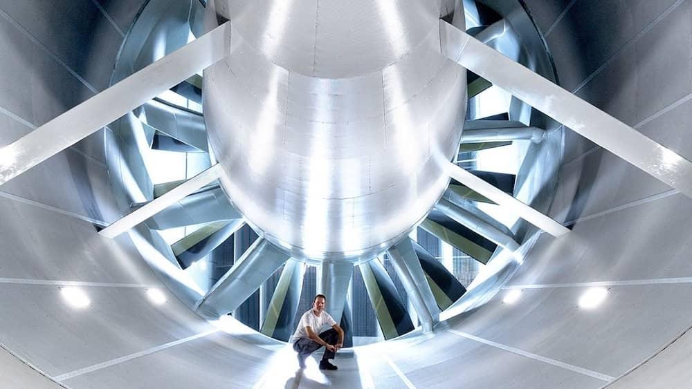 Front view of the main fan in the Volkswagen wind tunnel with an engineer crouching infront for scale